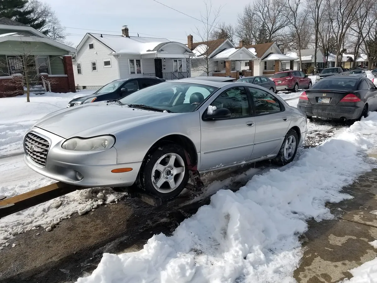 A silver Chrysler 300M stuck in the snow -- at a dealership this is an auction car, not a front-lot trade-in
