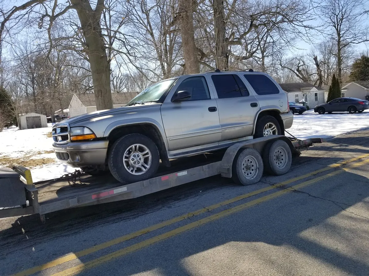 A Dodge Durango in fair shape rides a car trailer in Indianapolis -- even decent-looking SUVs can be worth more as parts than as trade-ins
