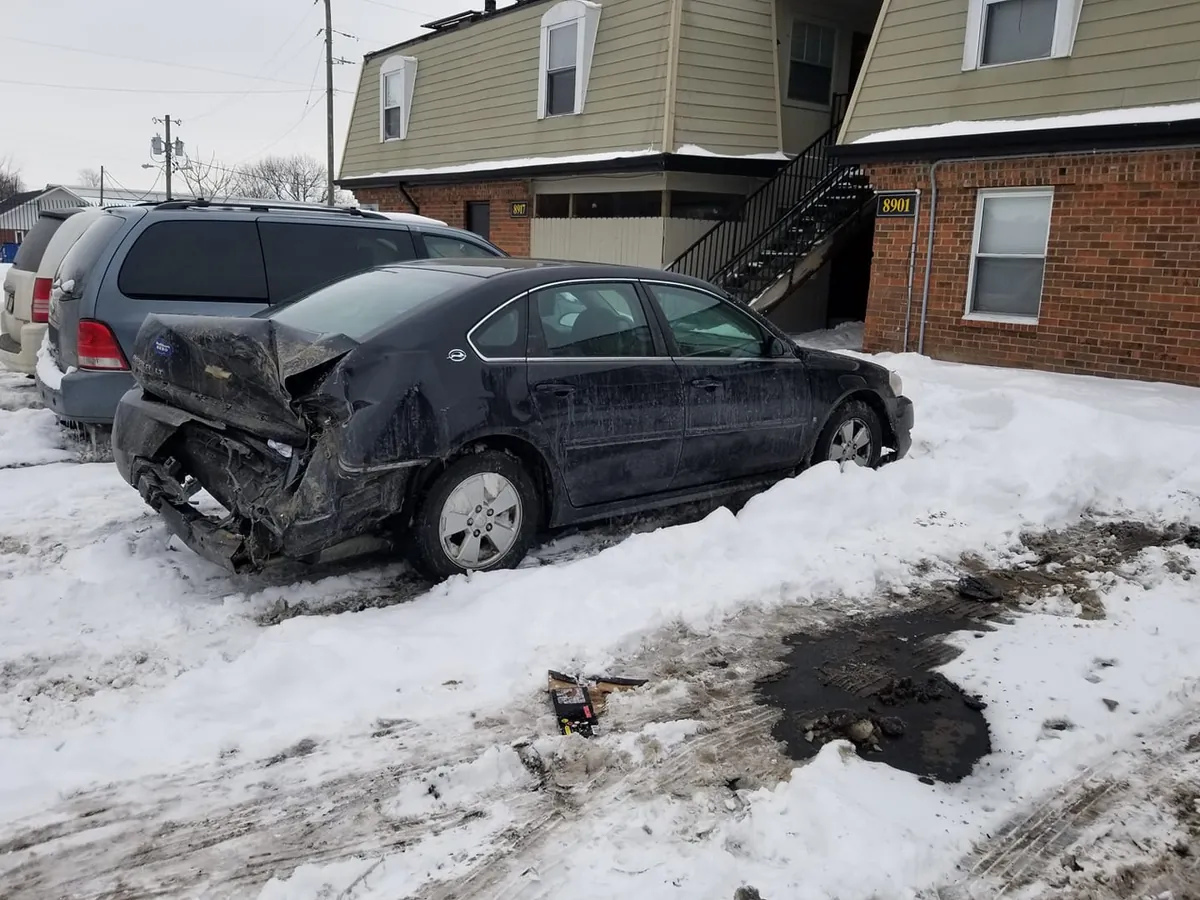 Rear-end collision damage on a black sedan -- crushed trunks and missing bumpers do not stop a cash sale in Indianapolis